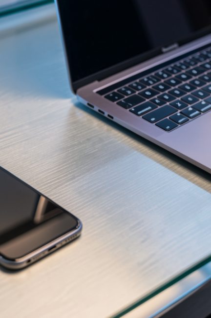 Bureau moderne high-tech avec un smartphone, un ordinateur portable et une tablette bien entretenus, éclairage doux et ambiance technologique.